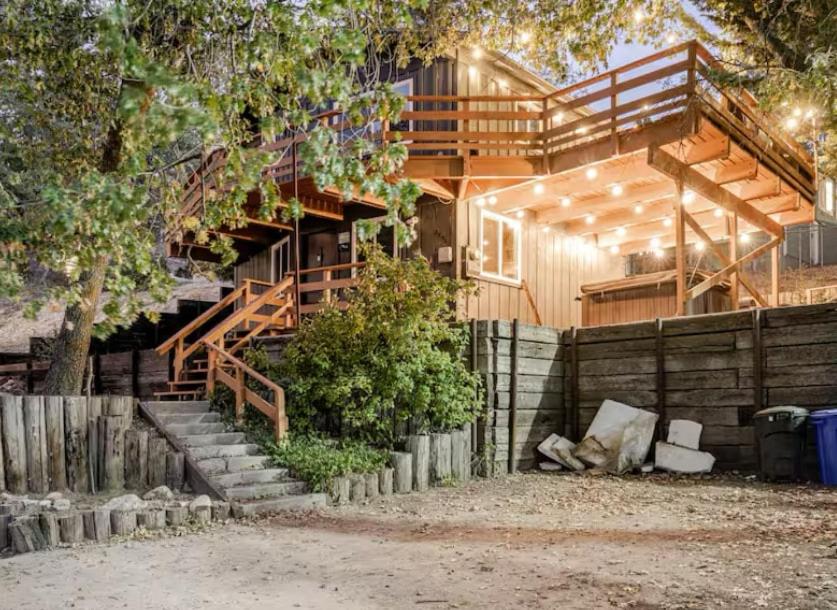 a wooden house with stairs and a fence at Snow Valley Retreat With Spa in Running Springs