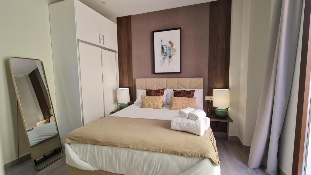 a bedroom with a large bed with two towels on it at Suspiro 202 Elegant Suite in Granada
