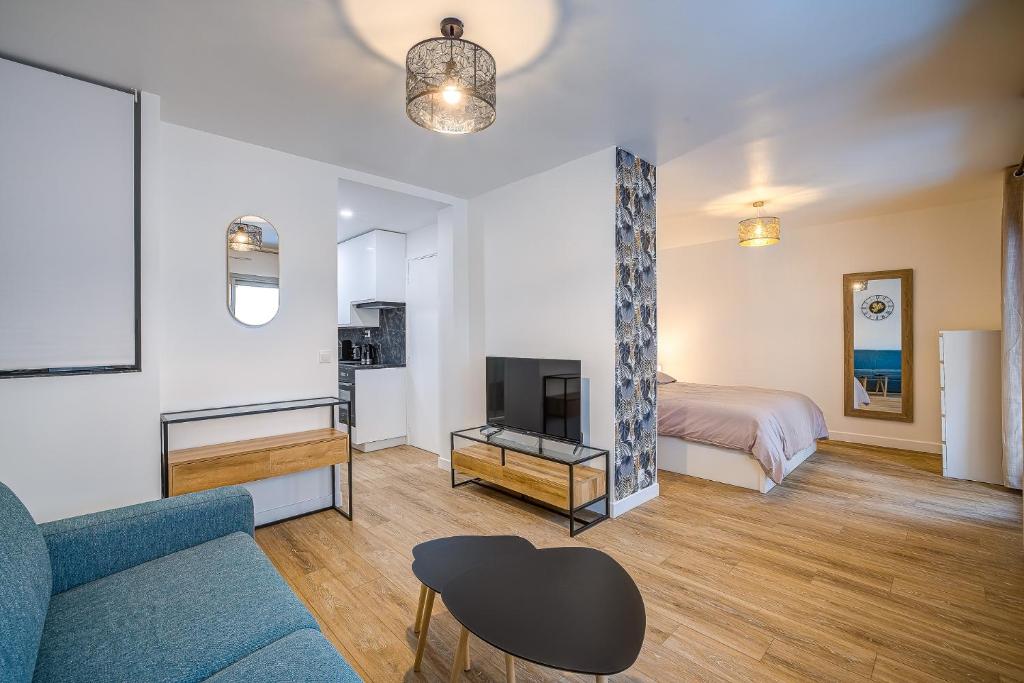 - un salon avec un lit, un canapé et une télévision dans l'établissement Antibes proche de la plage ,Appartement lumineux et climatisé, à Antibes