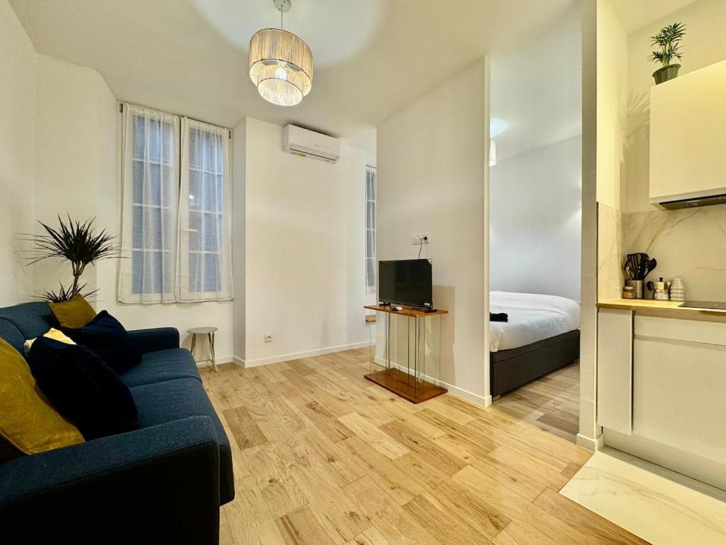 un salon avec un canapé bleu et une chambre dans l'établissement Charming Studio in the Heart of Nice, à Nice