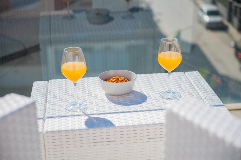 two glasses of orange juice and a bowl of food on a table at Appartamenti Paolone House Taormina Mare in Mazzeo