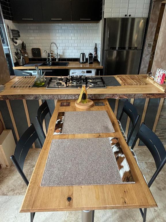 - une cuisine avec une table en bois et une cuisinière dans l'établissement Aux Angles, appartement cosy, bien equiper, vu sur lac, 5 min a pieds des pites, aux Angles