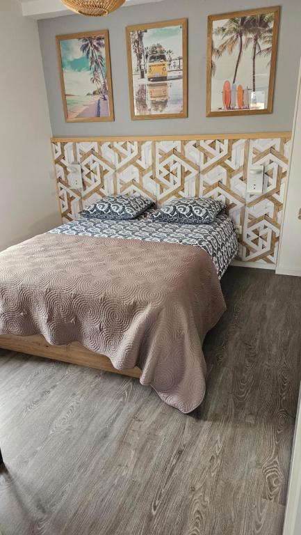 ein Bett mit einem hölzernen Kopfteil in einem Schlafzimmer in der Unterkunft Le "Chic en Ville" Centre historique, climatisé, wifi, Parking sous-sol inclus in Bergerac