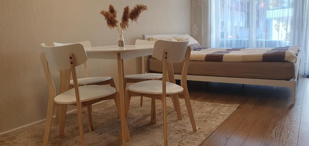 a table and chairs in a bedroom with a bed at Guboja in Nida