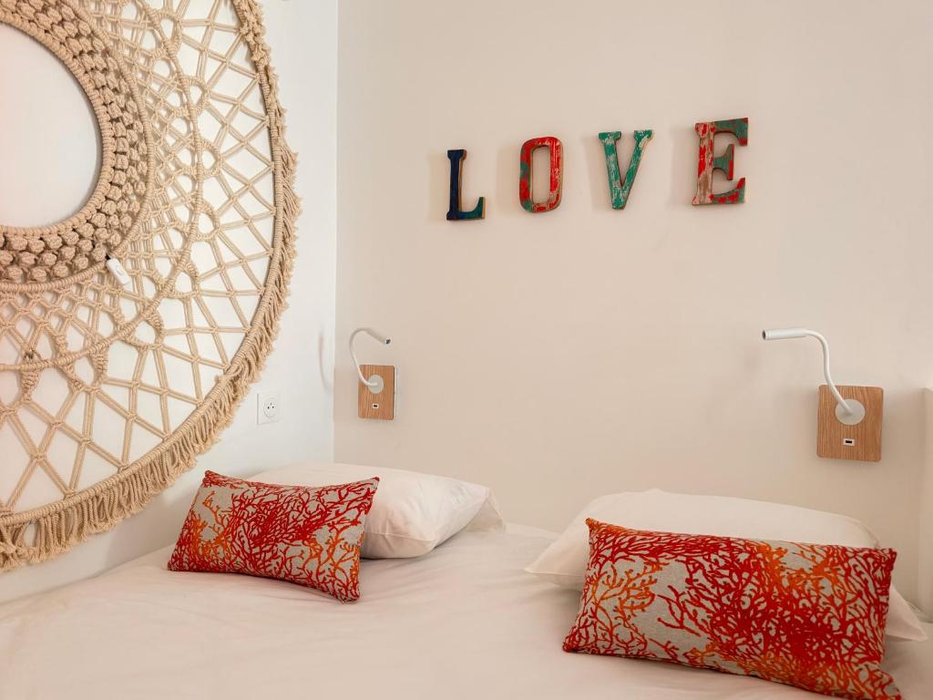 une chambre avec un lit avec deux oreillers et un miroir dans l'établissement Casa Bisou Cannes - BOHEME, à Cannes