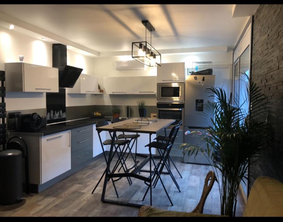 une cuisine avec une table et des chaises dans une pièce dans l'établissement Appartement climatisé hyper centre de Marseille, à Marseille