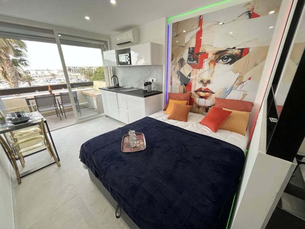 une chambre avec un lit avec un tableau sur le mur dans l'établissement Studio 2 couchage Cap d'Agde Naturisme CN0404-648, au Cap d'Agde