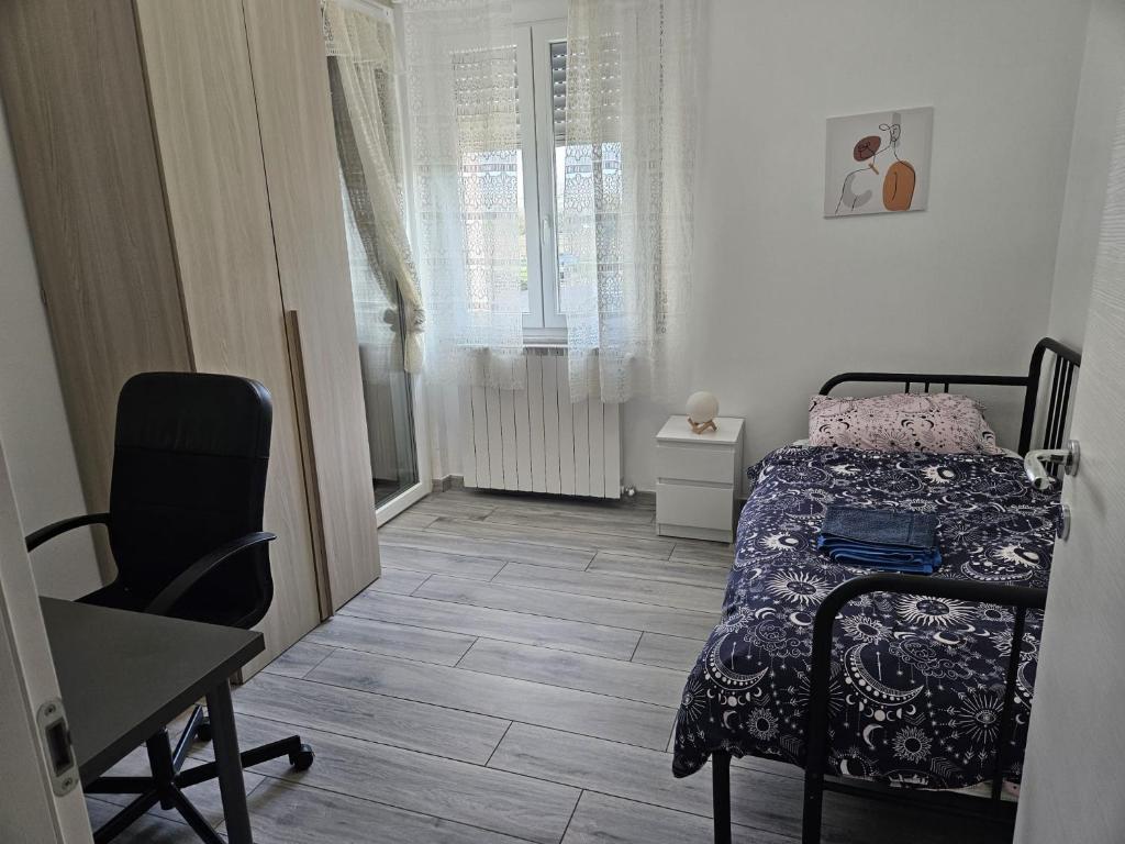 a bedroom with a bed and a desk and a window at Emanuele Home in Rho