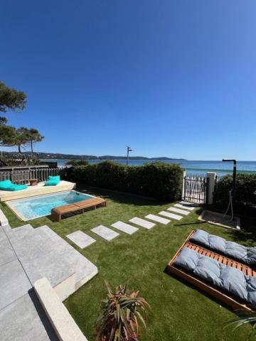 une arrière-cour avec une piscine et l'océan dans l'établissement Villa Récampado Les pieds dans l'eau avec piscine, à Cavalaire-sur-Mer