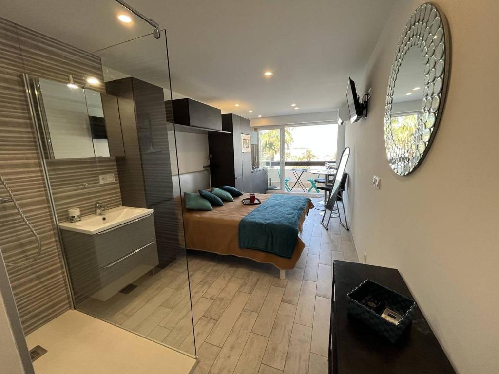 une chambre avec un lit et une salle de bain avec un lavabo dans l'établissement Studio 2 couchage Cap d'Agde Naturisme CN040-742, au Cap d'Agde