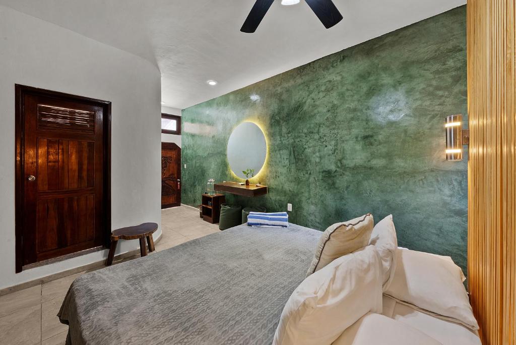 图卢姆卡内可海滩海滨生态酒店的一间卧室，配有一张床和绿色墙壁