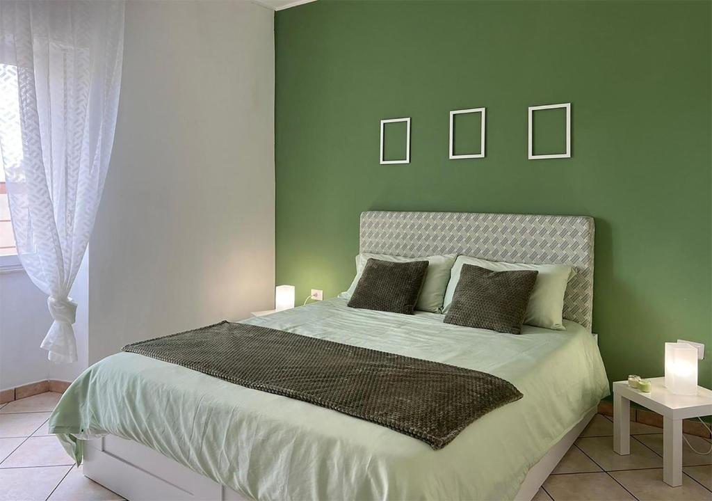 1 dormitorio verde con 1 cama con 2 almohadas en Rosemary s House Napoli City Apartment con Parcheggio, en Nápoles