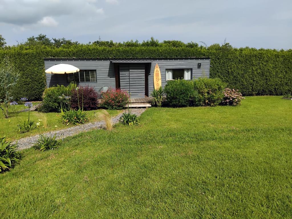 une petite maison dans une cour avec une pelouse dans l'établissement Maison Hamak, à Urrugne
