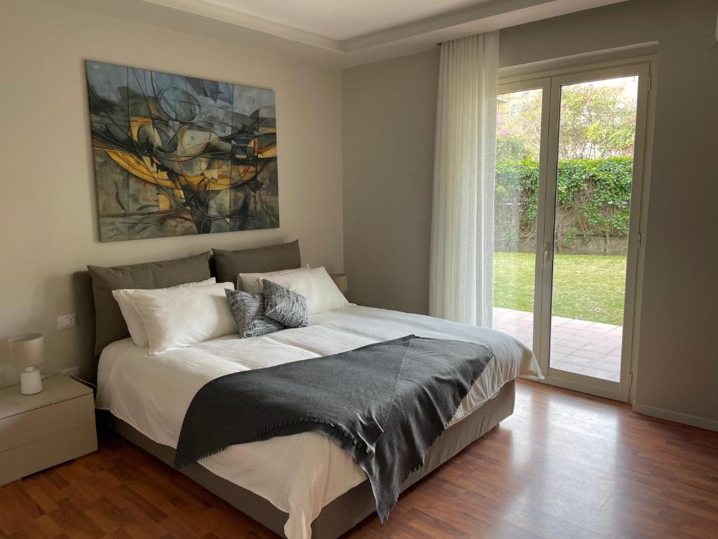 a bedroom with a bed with a painting on the wall at Magellano Home in San Gregorio di Catania