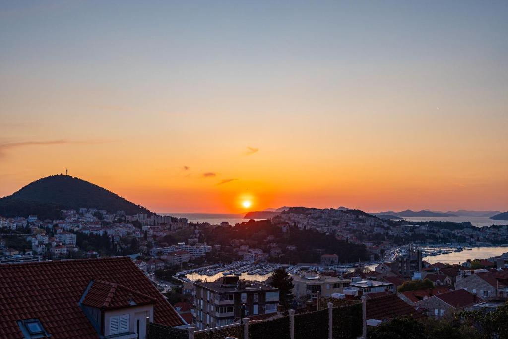 a view of a city with the sun setting at Dubrovnik Rooms 2 in Dubrovnik