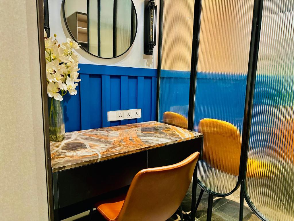 a table with two chairs and a mirror in a room at Scarletz Suites KLCC by M Suites in Kuala Lumpur