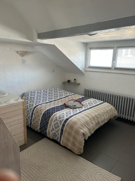 une petite chambre avec un lit et une fenêtre dans l'établissement Ammerschwihr vignoble Alsace, à Ammerschwihr