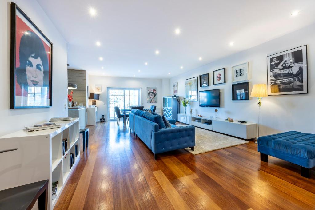 ein Wohnzimmer mit blauen Sofas und einem Fernseher in der Unterkunft South East Wind Apartment in Lagos