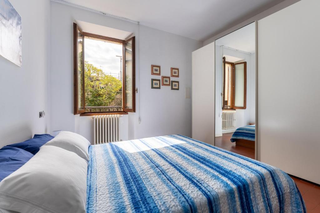 une chambre blanche avec un lit et une fenêtre dans l'établissement Casa Preziosa - Salò, à Salò