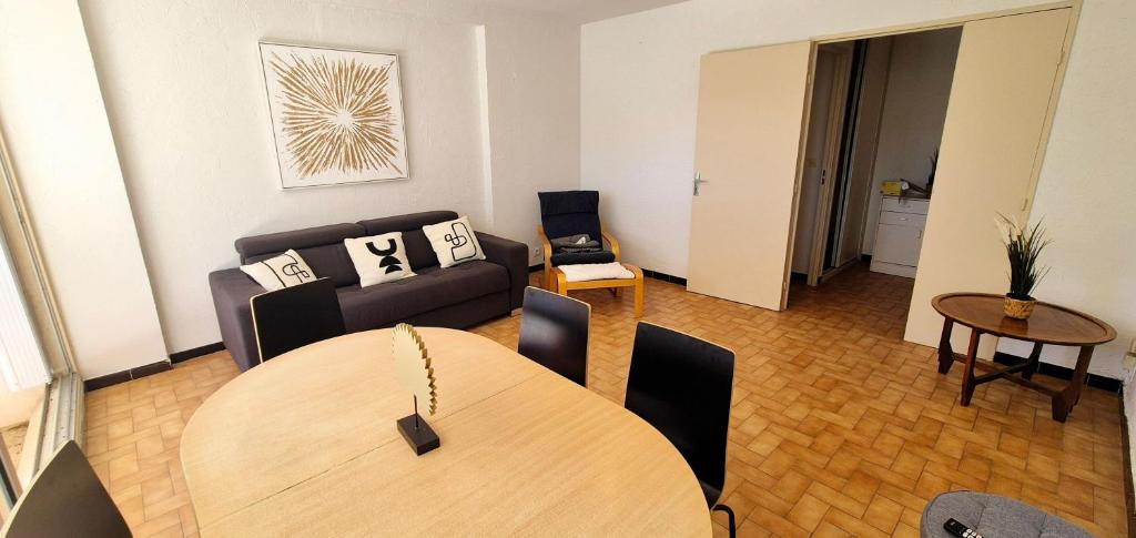 un salon avec une table et un canapé dans l'établissement Appart 8 pers, 80M2, parking privée, Mer & lac à pied, Face parc aquatique, à La Grande Motte