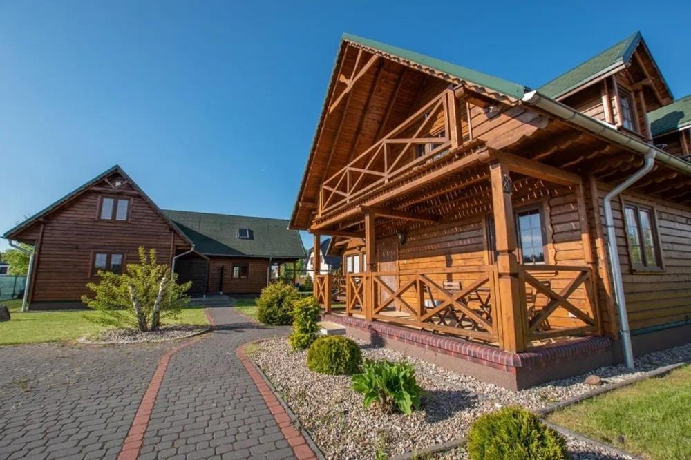 una gran casa de madera con un camino delante de ella en Domki w stylu góralskim Myśliwska 20, en Grzybowo