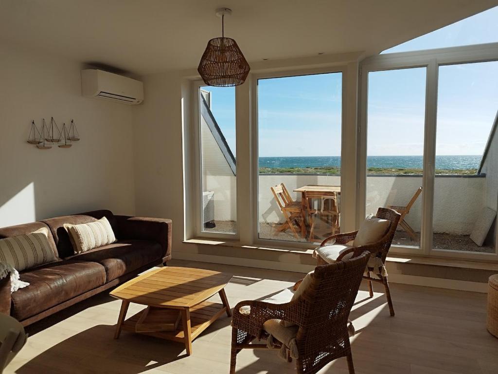 un salon avec un canapé et une table dans l'établissement Face mer Direct plage, à La Turballe