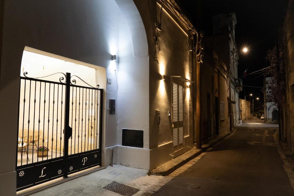 an empty alley at night with a gate at Corte Maria in Castri di Lecce