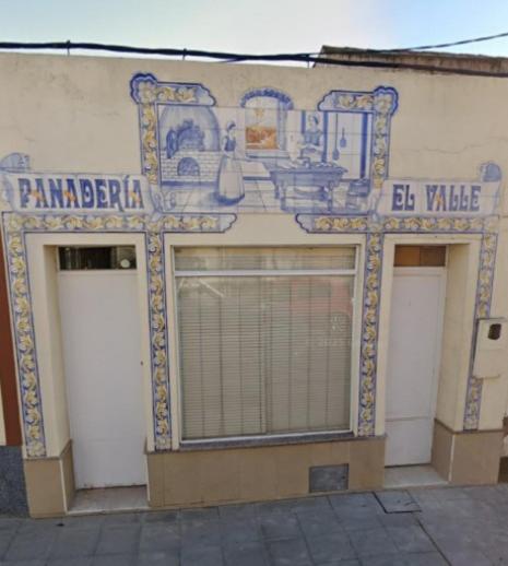 un edificio con tre porte del garage e un cartello sopra di Apartamento La Panaderia a Montijo