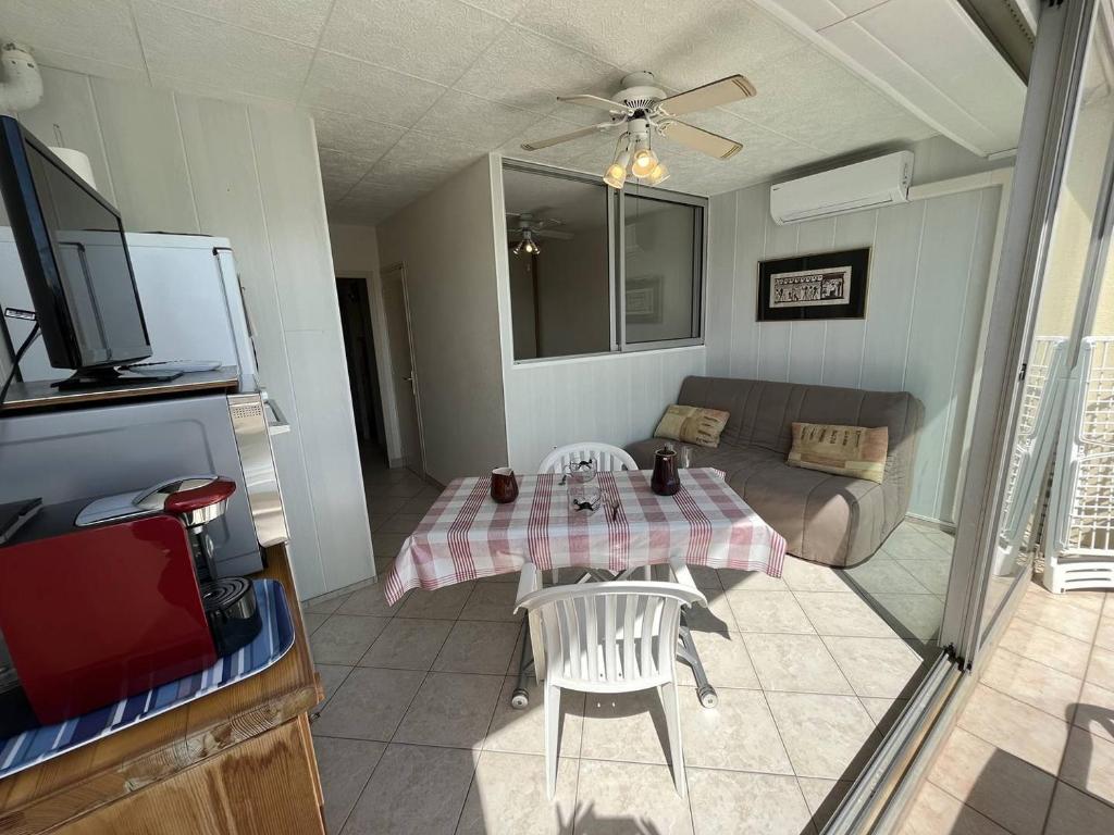 un salon avec une table et un canapé dans l'établissement Apt studio 2 couchages CAP D'AGDE NATURISME CN060-D28, au Cap d'Agde