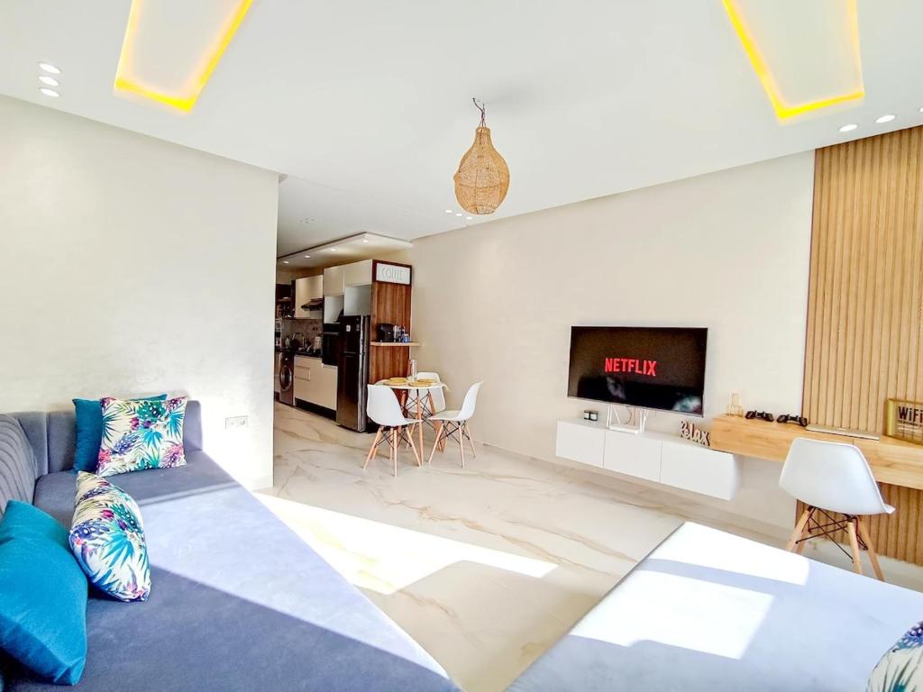 a living room with a couch and a tv at Luxury Condo Mehdia Beach, Parking, Netflix, Games, High Speed Internet in Kenitra