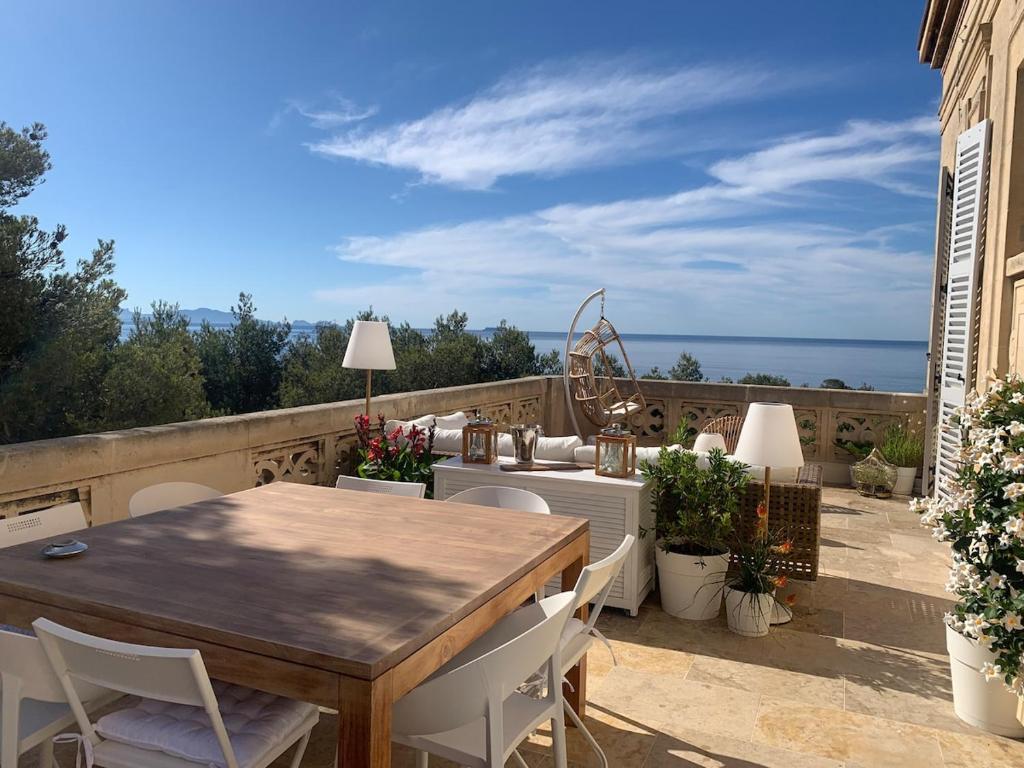 un patio avec une table et des chaises et l'océan dans l'établissement Vue mer exceptionnelle dans château, à Sausset-les-Pins