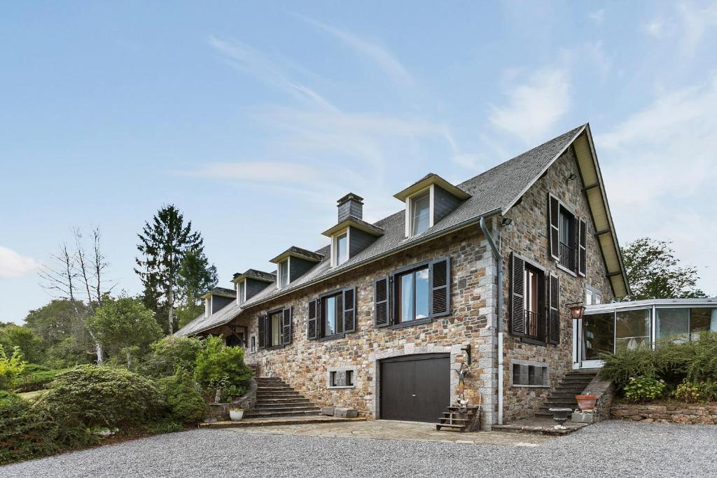 a large stone house with a garage at La Délice in Érezée