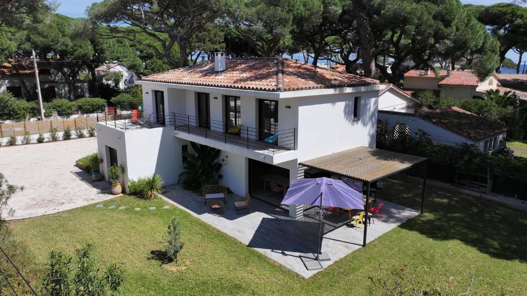 - une vue aérienne sur une maison blanche avec un parasol dans l'établissement Villa Les Pesquiers, à Hyères