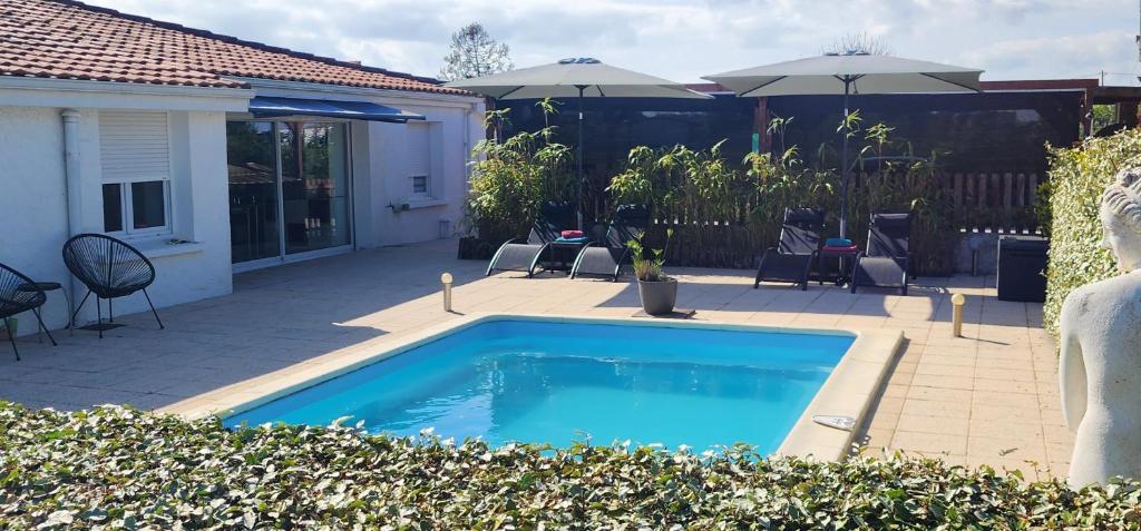 - une piscine dans une cour avec des chaises et des parasols dans l'établissement Villa de vacances avec Piscine, Billard & Pétanque, à Saint-Georges-de-Didonne