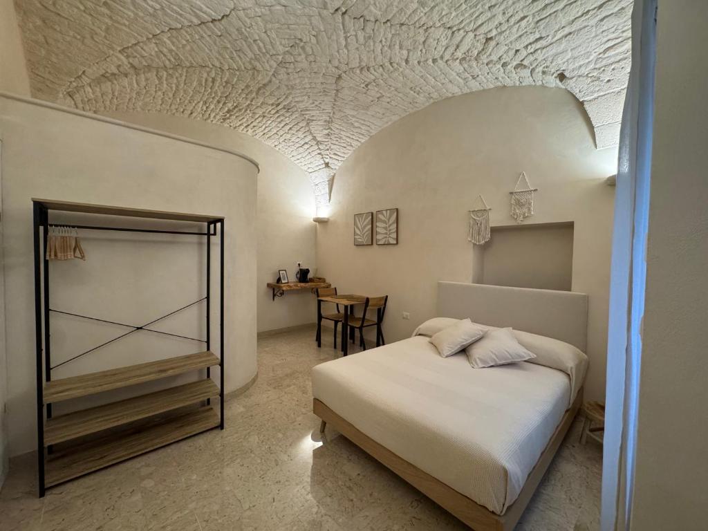 Un dormitorio con una cama y una mesa en una habitación. en Volta Meraviglia, en Martina Franca
