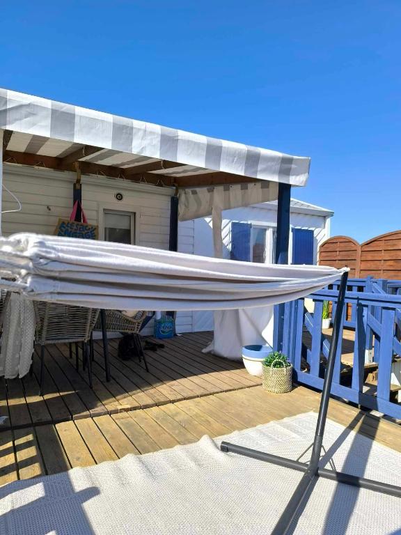 awning on top of a deck with a house at Mobilhome Metanova in Camiers