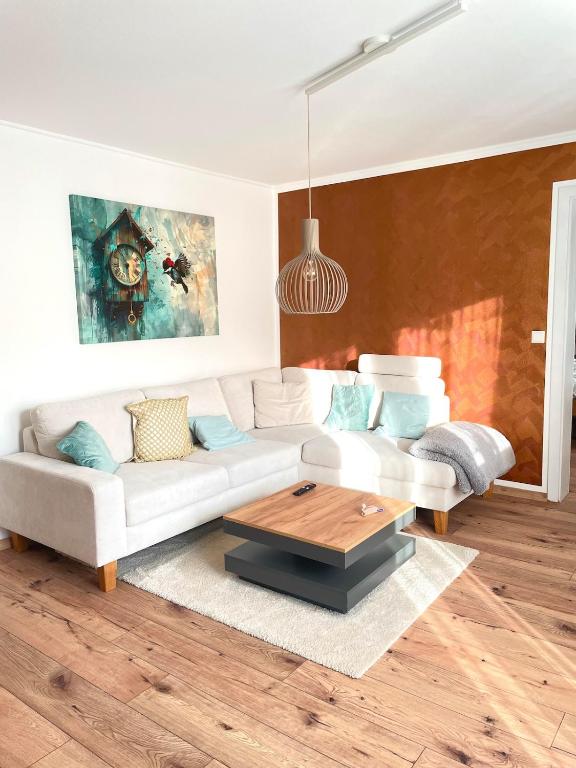 a living room with a white couch and a coffee table at Ferienwohnung Schwarzwaldnest im Heimbachtal in Loßburg