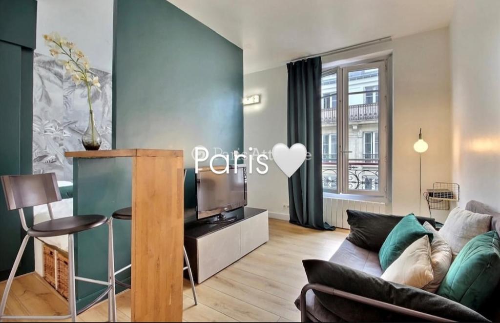 un salon avec un canapé et une télévision dans l'établissement PARIS with Love !, à Paris