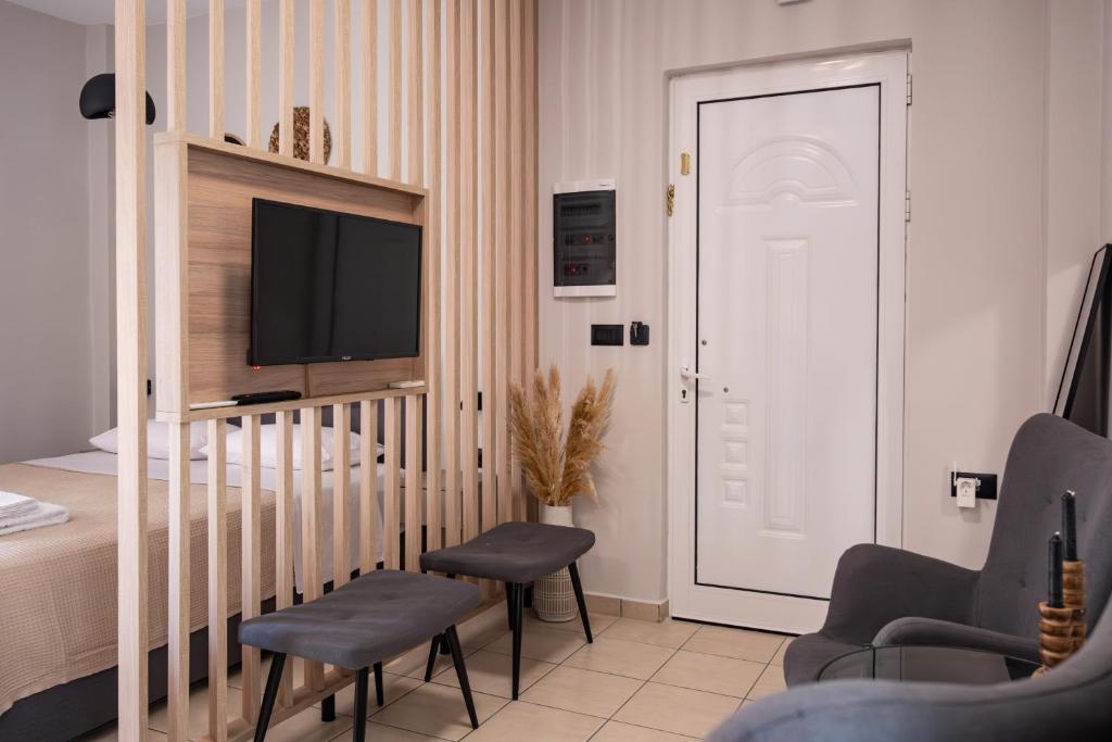 una camera con letto, TV e sedie di Nektaria Studio a Chania