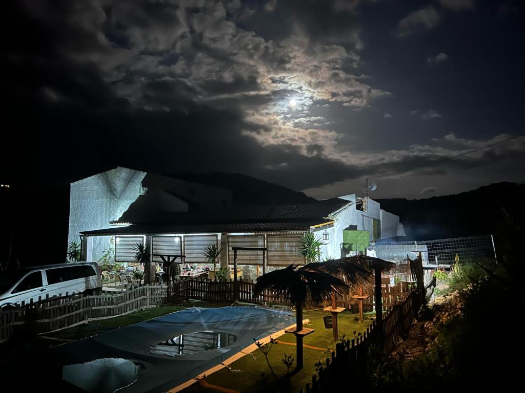 a building with a pool at night with the moon at CASA RURAL PRIVADA El ASIENTO LOS GEMELOS in Pruna