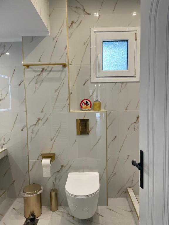 a bathroom with a white toilet and a window at Anastasias Holiday House in Stavros