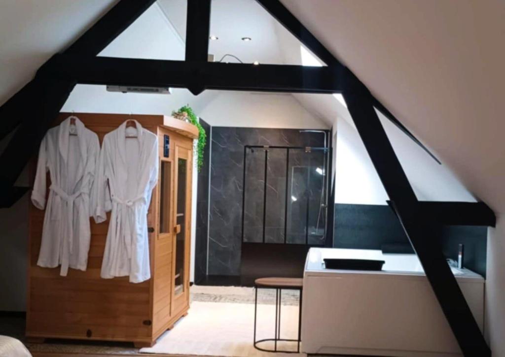 une pièce avec un placard avec des vêtements blancs accrochés dessus dans l'établissement Ô13 Loft privatif sauna balnéothérapie à 30min de Pairi Daiza, à Quiévrechain