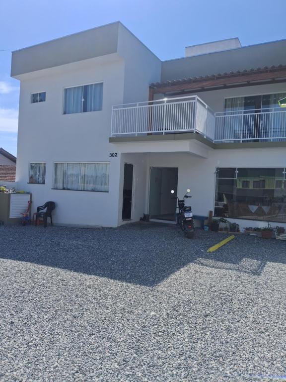 a large white house with a large driveway at Pousada casa da amizade in Penha