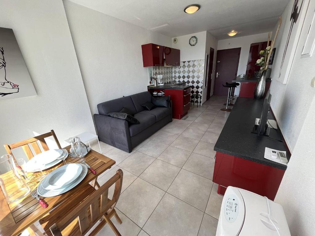 une cuisine et un salon avec un canapé et une table dans l'établissement Studio 2 couchages CAP D'AGDE NATURISME CN060-J301, au Cap d'Agde