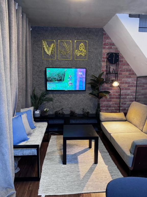 a living room with a couch and a tv at Cozy Rustic Corner House Subic in Subic