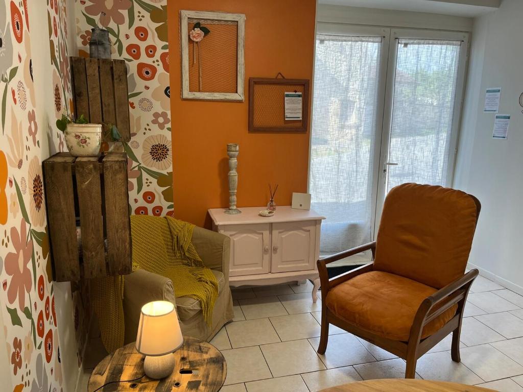 - un salon avec un canapé, une chaise et une table dans l'établissement Logis en Périgord - Entre bastides et vignobles - 2 personnes, à Saint-Aubin-de-Lanquais