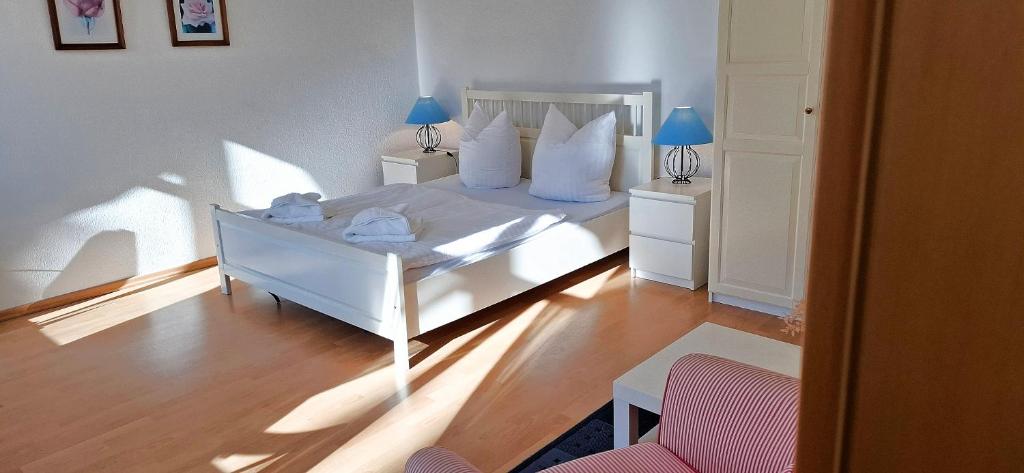 een slaapkamer met een wit bed met blauwe lampen bij Villa Fortuna Gästehaus App Hiddensee in Ahlbeck