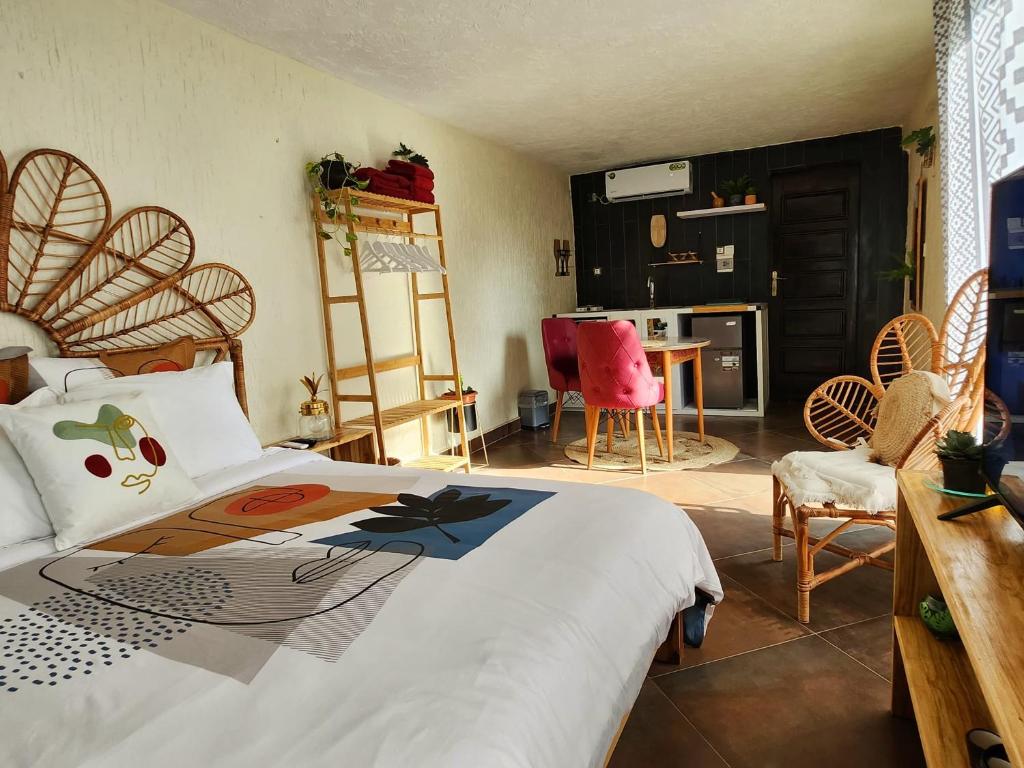 una camera da letto con un letto, un tavolo e delle sedie di Blandine's Little Heaven a Lomé