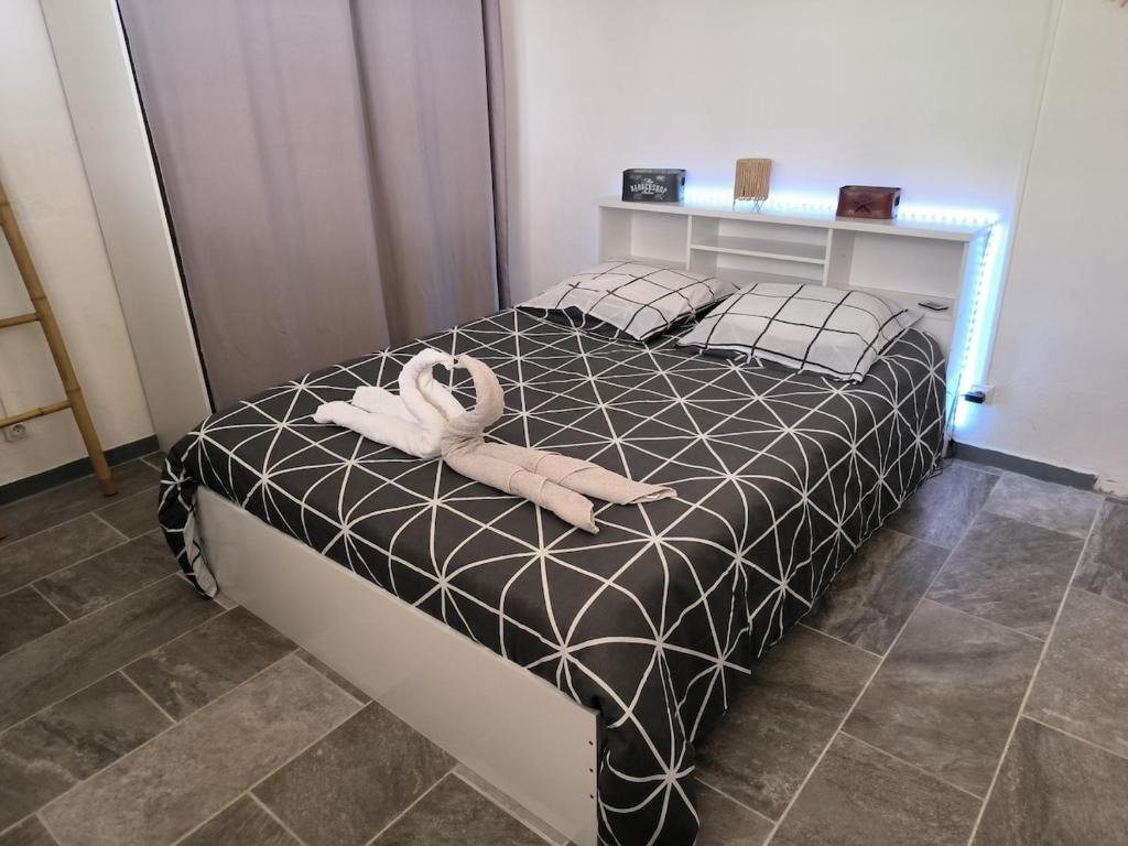 a bedroom with a bed with a stuffed animal on it at studio Caraïbes in Les Trois-Îlets