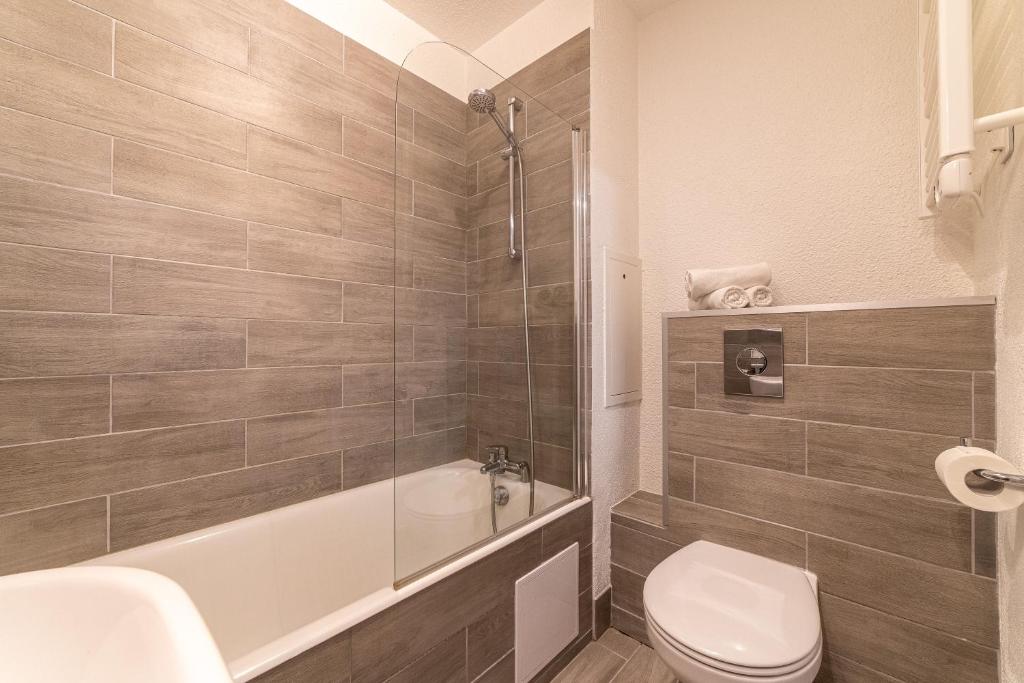 a bathroom with a toilet and a tub and a sink at La Cigale Varoise - Hyères La Plage in Hyères